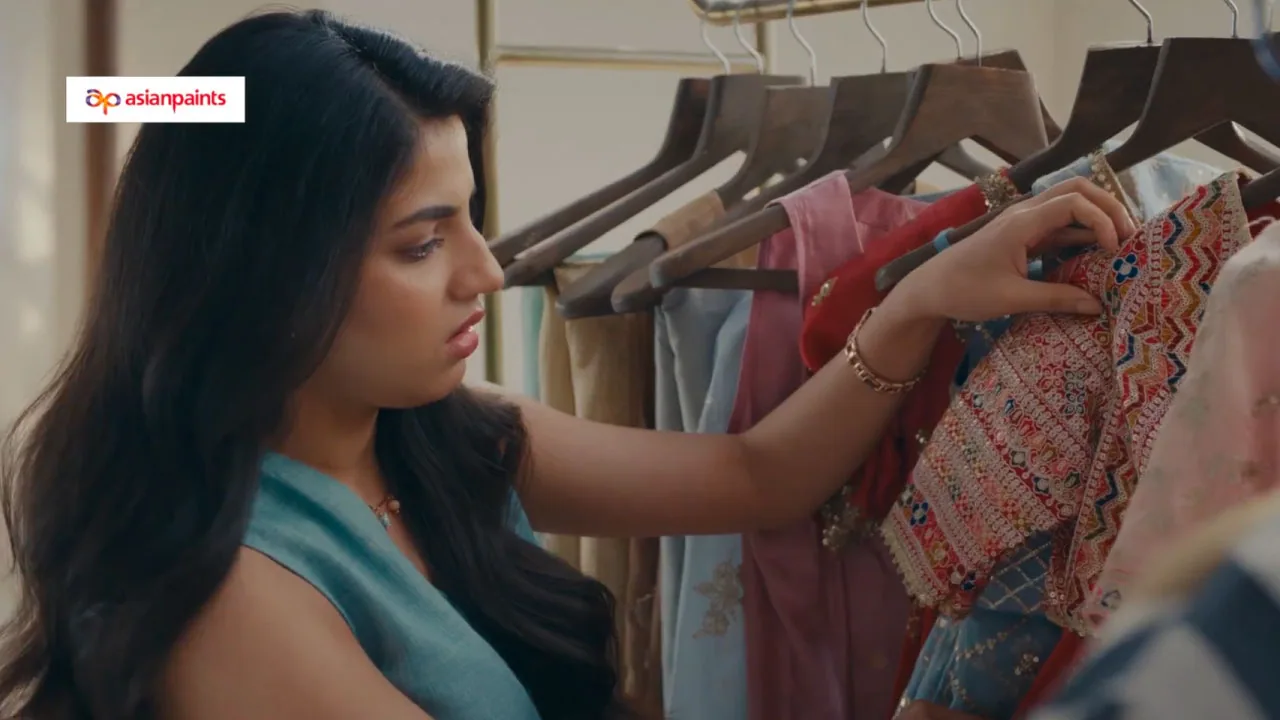 A woman choosing wedding outfits while a painter works on the wall behind her, from the Asian Paints Beautiful Homes film