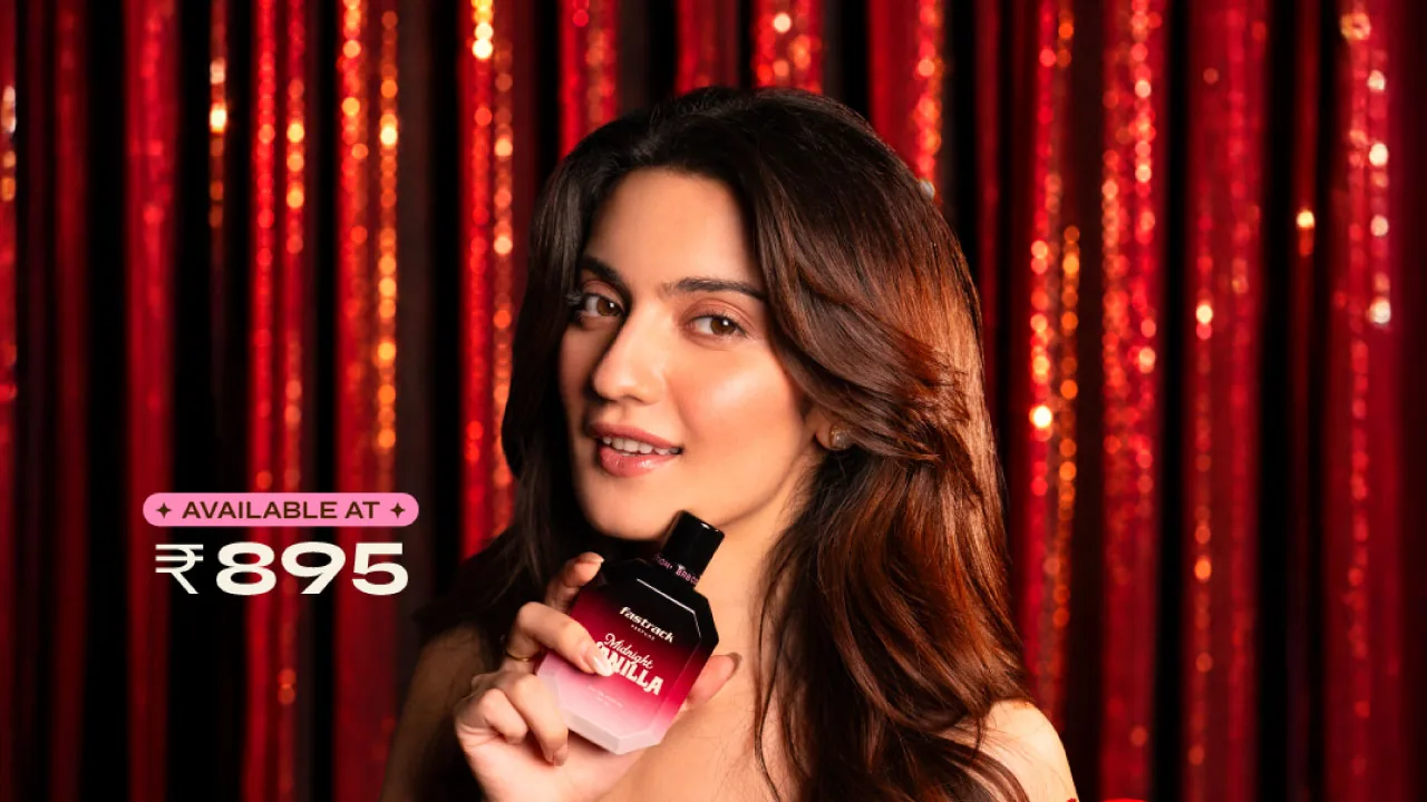 Pratibha Ranta holding the Midnight Vanilla bottle against a red fringe backdrop, from the Fastrack Perfumes gourmand film