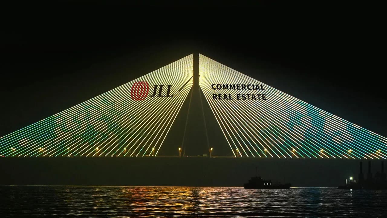 A cable-stayed bridge lit by a projector beam, as halftone cutouts, for a brand activation on a Mumbai landmark