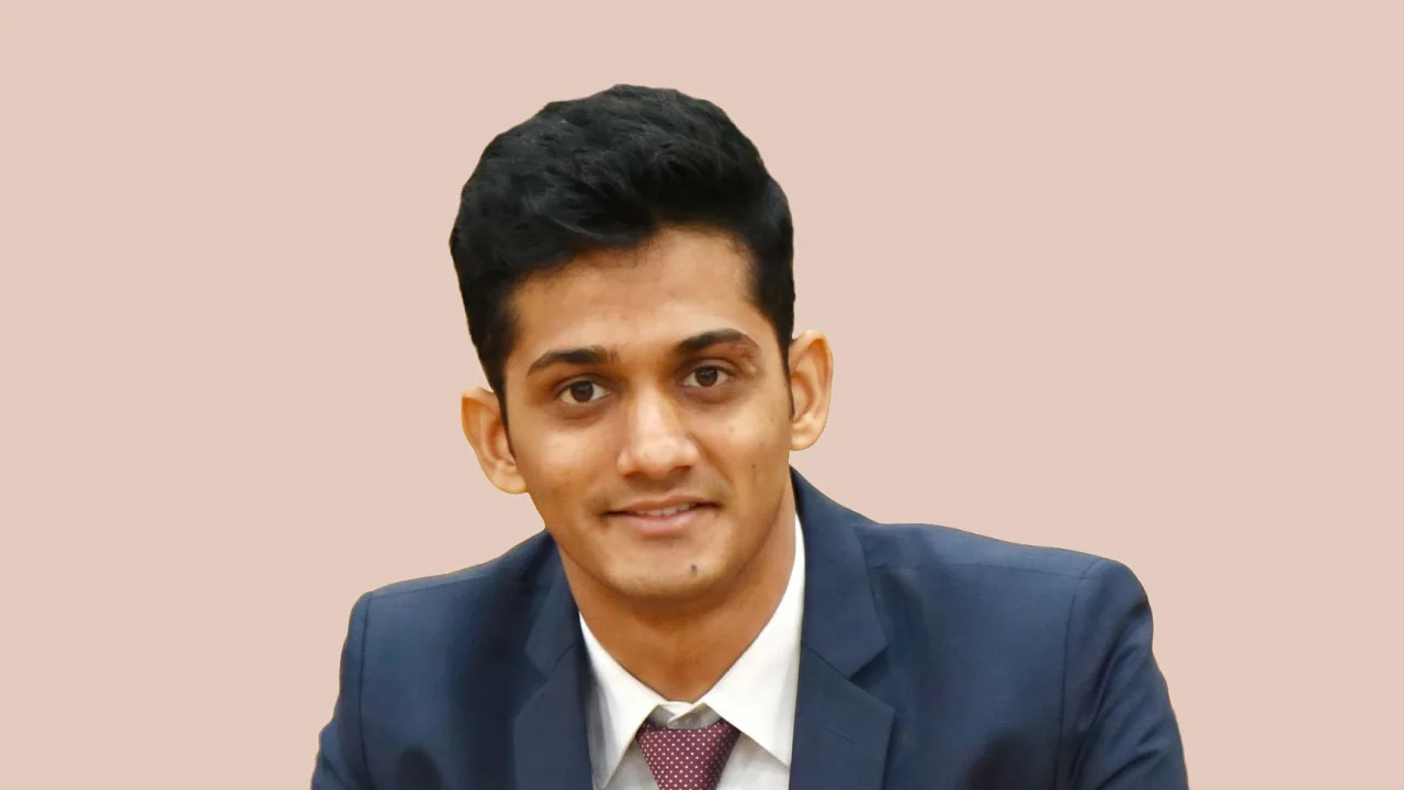 Sharath Kumar, AVP marketing and platform head at Hector Beverages, seated at a desk with hands clasped on butter yellow