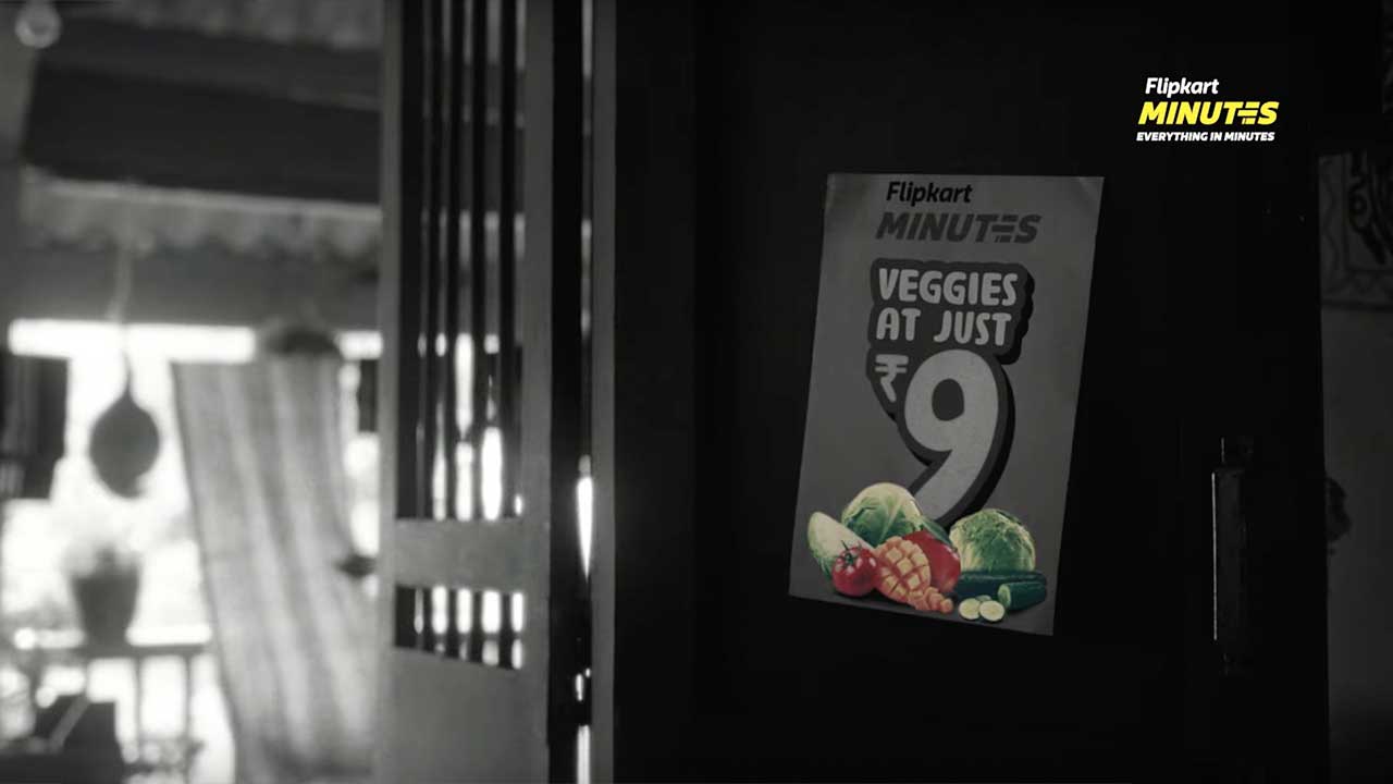 A Flipkart Minutes poster advertising vegetables at nine rupees in a black and white kitchen scene