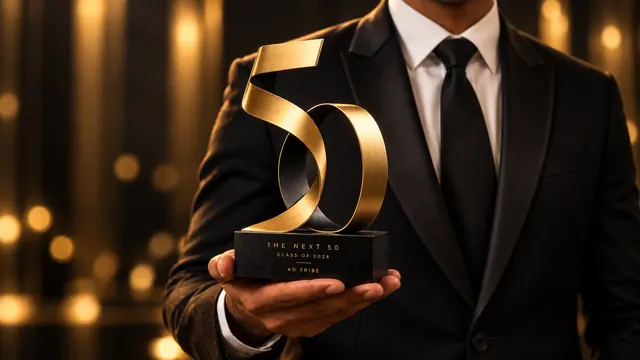 A member of the class holding The Next 50 trophy